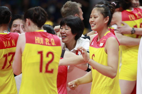 Lang Ping (center), coach of China's women's volleyball team, celebrates with her team members after the team won gold at the Rio de Janeiro Olympics on August 21, 2016. (Photo/XINHUA)
