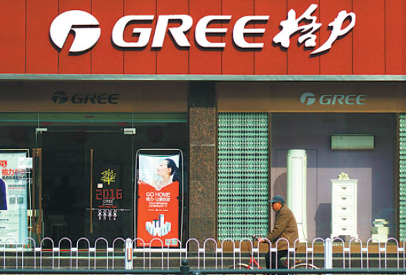 A person passes by a Gree outlet in Yichang, Hubei province. (Zhou Jianping / For China Daily)