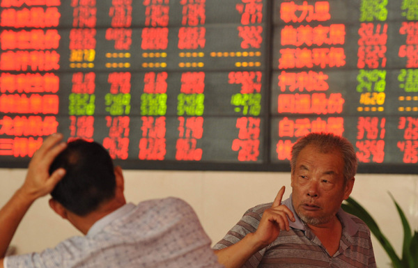 Investors talk about stocks in a securities trading center on Tuesday in Fuyang, a city in eastern China's Anhui province. QI WEN/FOR CHINA DAILY