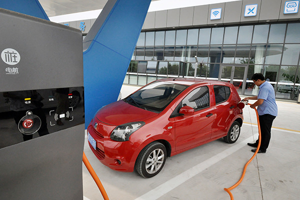 A man charges his new energy vehicle in Rizhao, Shandong province. The sector sees rapid growth in China. (Photo/China Daily)