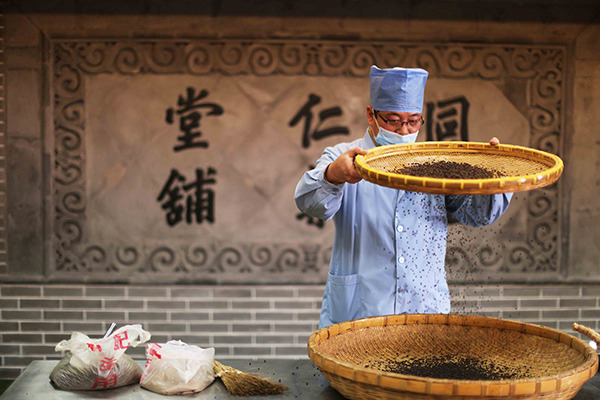 A pharmacist processes a traditional Chinese medicine at a Beijing Tongrentang Group Co Ltd's factory in Beijing. (Photo/China Daily)