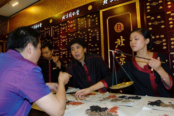 Beijing Tongrentang Group Co Ltd's employees prepare traditional Chinese medicine for their customers at a Tongrentang pharmacy in Chengdu, Sichuan province. The Chinese TCM company plans to broaden its overseas business by opening at least 200 branches over the next five years. (Photo/China Daily)
