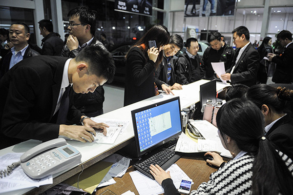 A car dealership experiences a rush in trade on the night before buying limit policies were introduced by Shenzhen on Dec 28, 2014. (Photo/China Daily)