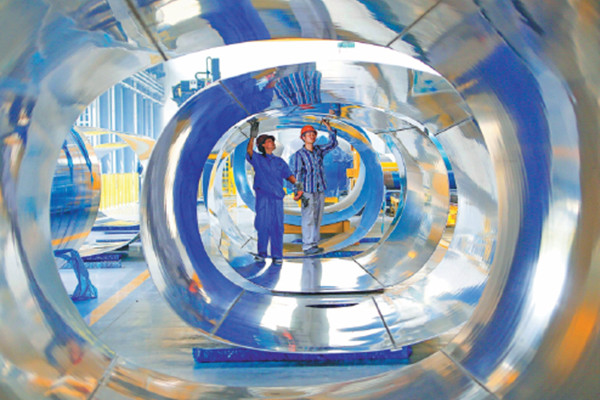 Workers check the steel tanks used to produce a special type of tanker in Tianming Special Vehicle Manufacturing Company, which mainly exports to the Middle East, South America and Africa, in Tuowang Port Industry Zone in Lianyungang, east China's Jiangsu province in June. The competitive manufacturing industry remains a pillar of the Chinese economy. (Photo/China Daily)
