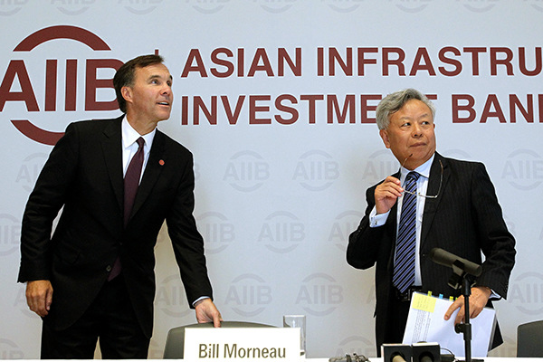 Jin Liqun, president of the Asian Infrastructure Investment Bank, and Canadian Finance Minister Bill Morneau attend a news conference in Beijing on Wednesday. (Photo/China Daily)