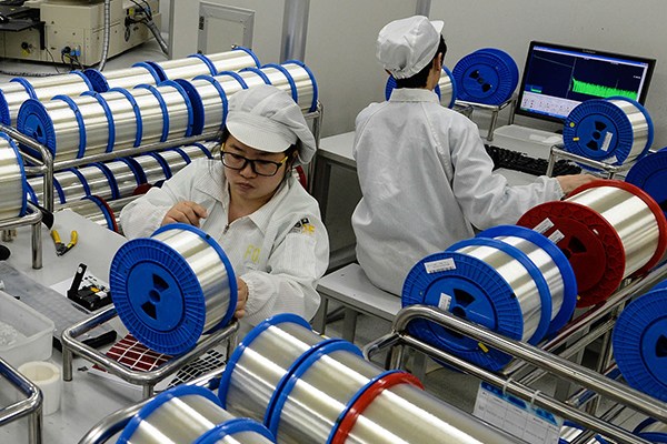 Workers inspect products at a workshop of Hengtong Group Co Ltd, a Jiangsu-based company. (Photo/Xinhua)