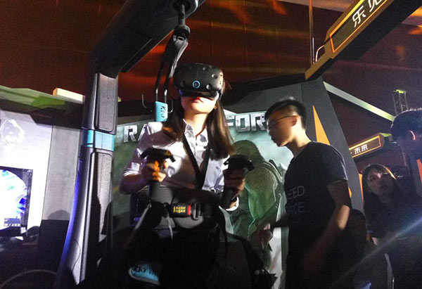 A woman tries VR games in Beijing on August 27, 2016 in Beijing. (Photo by Song Jingli/chinadaily.com.cn)