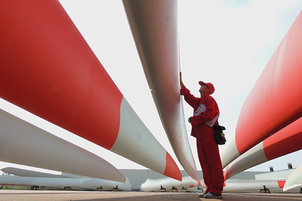 A technician inspects wind turbine blades at a factory in Lianyungang, Jiangsu province, in September last year. (Photo/China Daily)