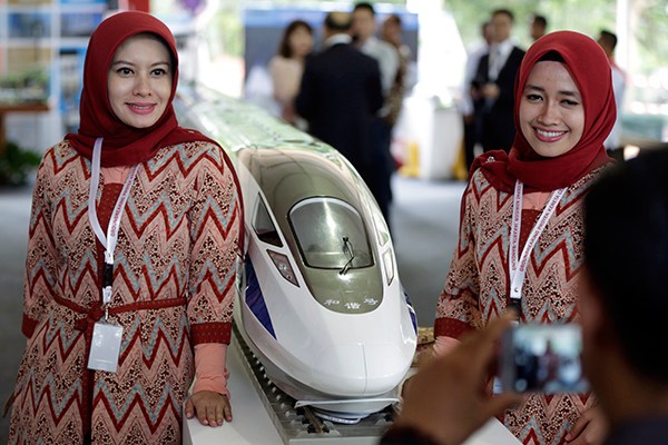 Two Indonesian women pose for a photo in front of a model of China's high-speed train in Walini, West Java province, on Jan 21, 2016 to mark the launch of the Jakarta-Bandung high-speed railway project. (Photo/Xinhua)