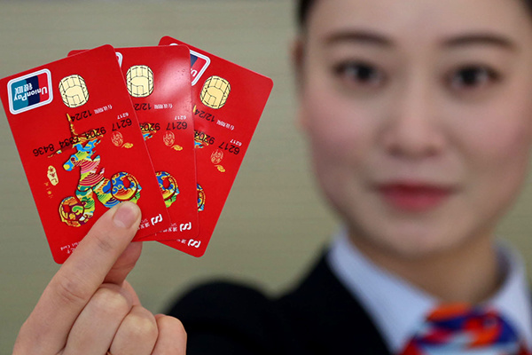 A bank clerk in Huai'an, East China's Jiangsu province, holds up a new type of bank card incorporating an electronic chip, which was introduced last year. (Photo/China Daily)