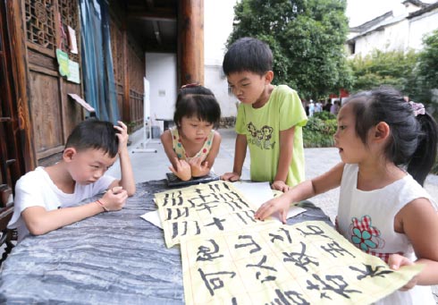 Children practice calligraphy in Tonglu county. (Photo by Wang Zhuangfei/China Daily)