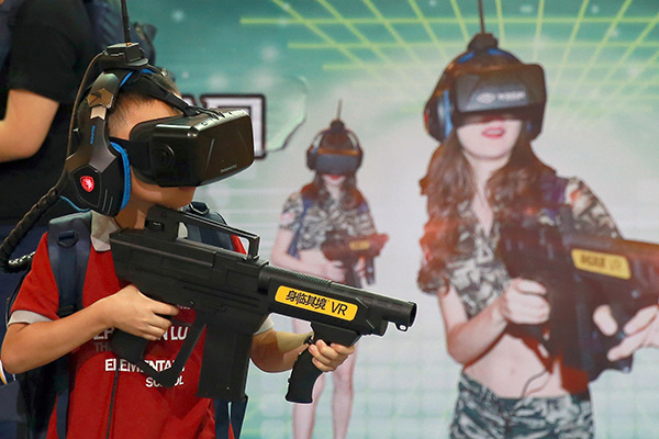 A boy tries VR games at an urban science festival in Beijing. (Photo/China Daily)