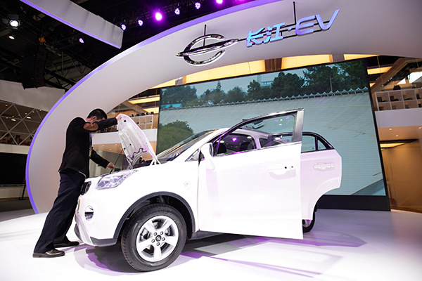 A visitor checks a new-energy car at the Beijing auto show in May. (Photo/China Daily)