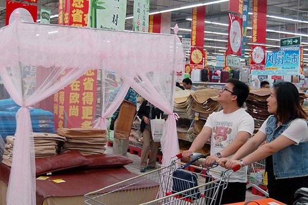 A couple select mosquito net at a supermarket in Suzhou, Jiangsu province. Chinese families have a tradition of using mosquito nets during the summer. (Photo/China Daily)