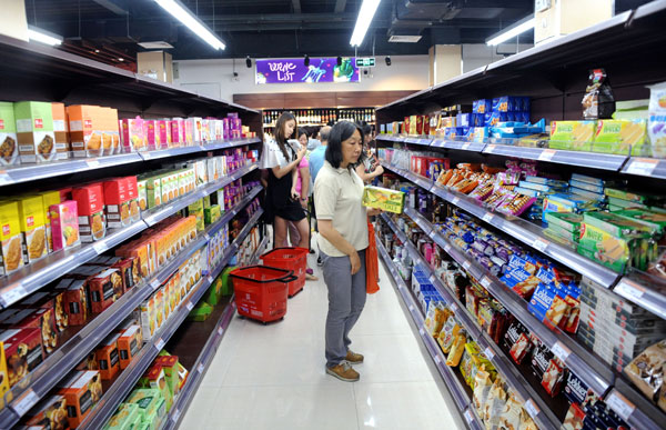 A shopper holding a box of cookies eyes other imported foods at a mall in Shanghai. (Yang Yi /China Daily)