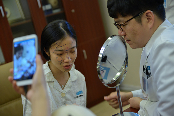 A girl receives a doctor's review in a hospital in Chengdu, Sichuan province, before going through a cosmetic surgery. (Photo/China Daily)