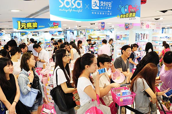Shoppers use Alipay to pay their bills at the Sa Sa International store in Hong Kong. Alipay operator Ant Financial Services Group aims to sign up 8,000 local merchants before the end of the year in the city. (LONG WEI / FOR CHINA DAILY)