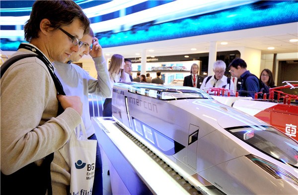 Visitors examine a CRRC transcontinental train model at the Inno Trans 2016, the largest rail industry event in the world, which opened in Berlin on Tuesday.(CHINA DAILY)