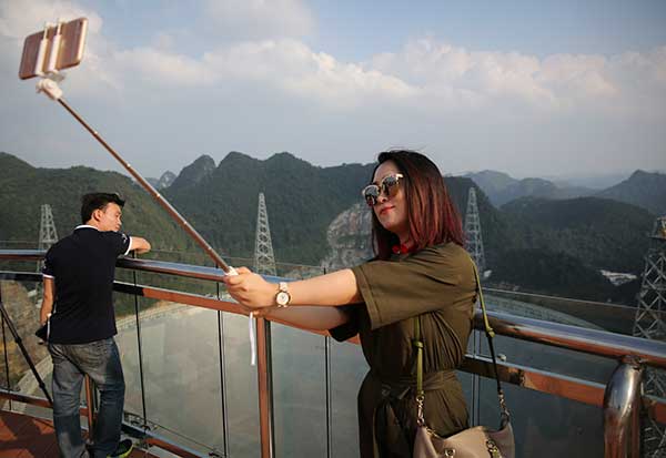 A news reporter takes a selfie at the telescope site in Pingtang, Guizhou province, on Saturday. The scenic spot will open to visitors on Monday.Hou Liqiang / China Daily
