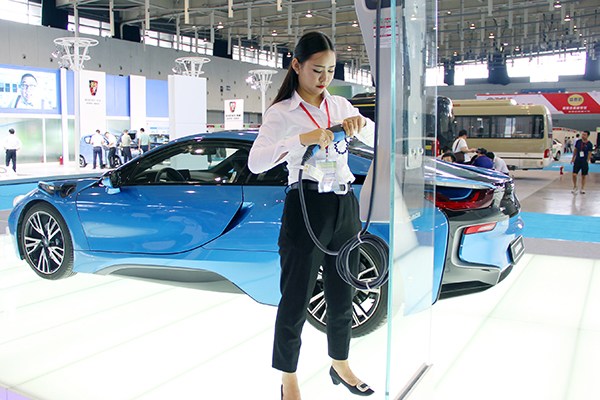 An exhibitor prepares a charger for a new energy car at an energy conservation and new energy auto show in Nanjing, Jiangsu province, on Sept 7. (Photo/China Daily)