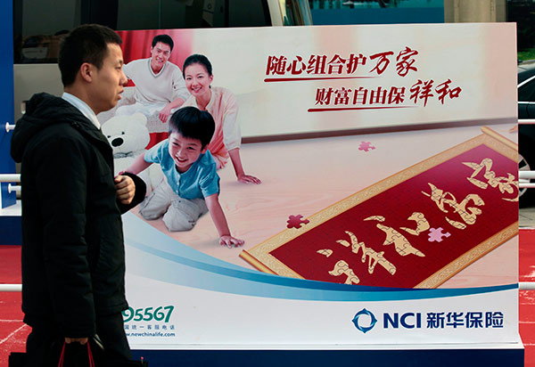 A man passes by the billboard of New China Life Insurance Co at an insurance fair in Beijing. (Photo:China Daily/A Qing)