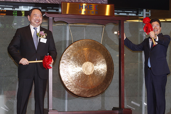 Postal Savings Bank of China Chairman Li Guohua (left) and Executive Director and President Lyu Jiajin pose with a gong during the listing of the bank at the Hong Kong Stock Exchange on Wednesday. (Photo/China Daily)