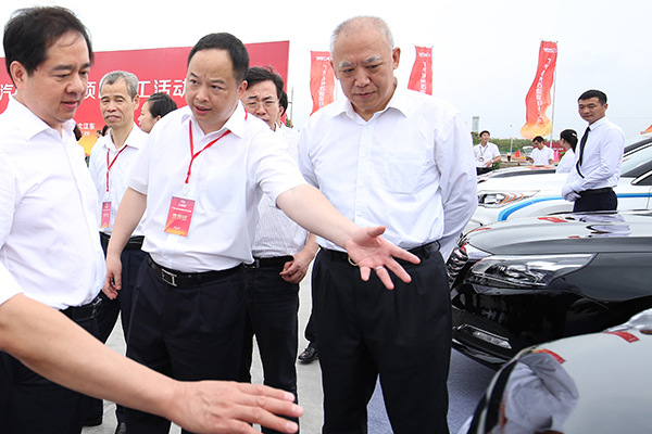 Yu Jun (center), general manager of GAC Motor Co, introduces car models to guests in Hangzhou, Zhejiang province, on Wednesday. (Photo provided to China Daily)