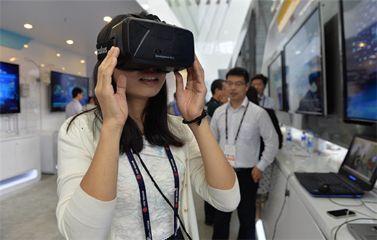 A visitor tries a VR device at a promotional event in Shanghai in July. (Photo/Xinhua)