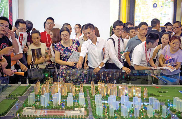 Prospective buyers attend a real estate trade fair in Chengdu, capital of Sichuan province, on Oct 3. People will only be allowed to purchase one property in certain areas of the city, while those buying a second property will need to make a down payment of no less than 40 percent of the purchase price, the local government says. (Photo/China Daily)