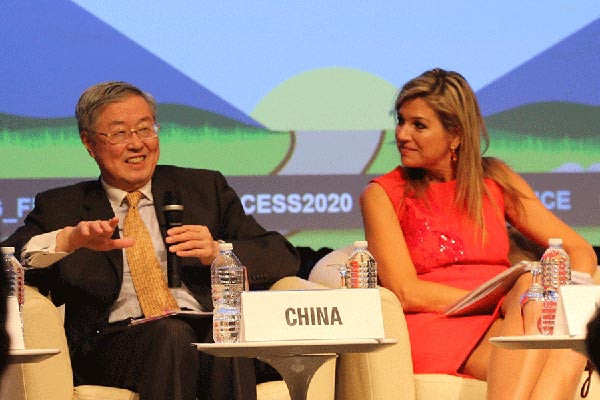 Zhou Xiaochuan, governor of the People's Bank of China, the central bank, speaks at seminar on financial inclusion held at the World Bank headquarters in Washington on Friday during the 2016 IMF/World Bank annual meeting while Queen Maxima of the Netherlands looks on. (Photo by Chen Weihua/China Daily)