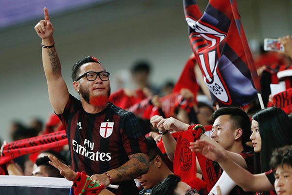 Fans of the AC Milan soccer club at a contest between the team and Real Madrid in Shanghai.A Chinese consortium signed a preliminary deal for a 99.93 percent stake of AC Milan this August. (Photo provided to China Daily)