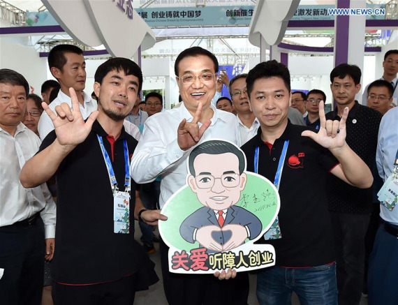 Chinese Premier Li Keqiang (C) poses for a photo with entrepreneurial team members at the main venue of the National Mass Innovation and Entrepreneurship Week in Shenzhen, south China's Guangdong Province, Oct. 12, 2016.  (Photo: Xinhua/Li Tao)