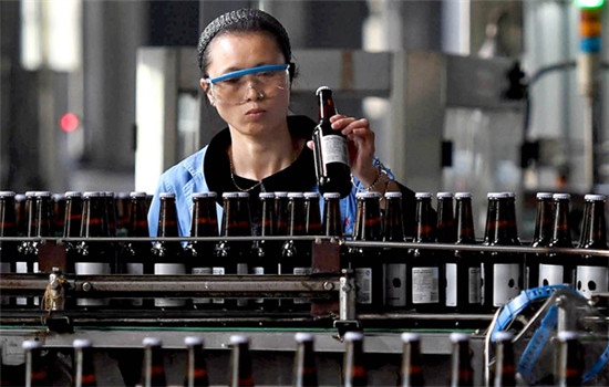A technician inspects a craft beer production line at a brewery in Yiyang, Hunan province. (Photo by Li Ga/For China Daily)