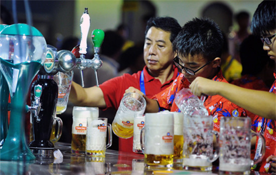 Chinese consumers enjoy drinks during a beer festival in Qingdao, Shandong province. Along with the swelling demand for high-end beer in China, investments in the craft beer segment have been rising in recent years. (Photo provided to China Daily)