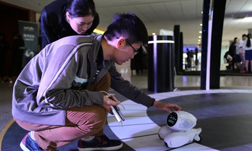 People check out an AI-powered robot at the AI World 2016 held in Beijing on Tuesday. (Photo/GT)
