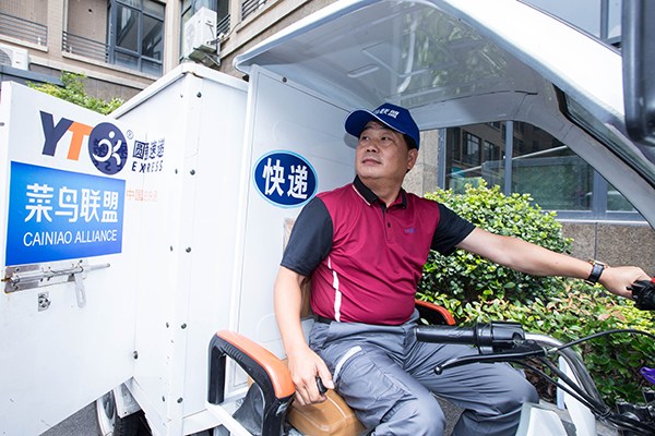 Yu Weijiao, founder and chairman of Shanghai Yuantong Express Logistics Co Ltd, delivers packages for customers in Hangzhou, Zhejiang province. (Photo/China Daily)