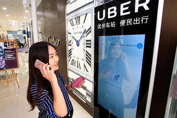 A woman uses Uber Technologies Inc's car-hailing service via an electronic screen in Tianjin. (Provided to China Daily)