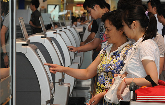 Passengers use the self-service boarding system at the Beijing Capital International Airport. (Photo/China Daily)