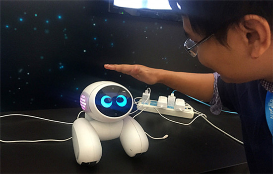 A man interacts with an artificially intelligent (AI) robot at the 2016 AI World Expo, held in Beijing on Oct 18, 2016.(Photo/People's Daily Online)