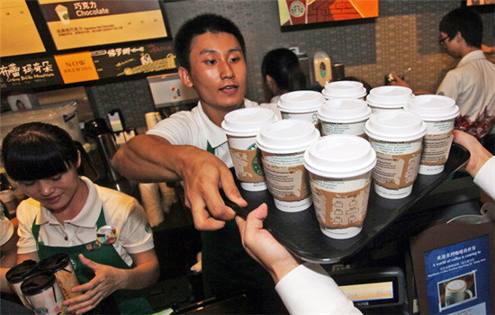 Employees serve customers at a Starbucks store in Fuzhou, Fujian province. (ZHENG SHUAI/For China Daily)