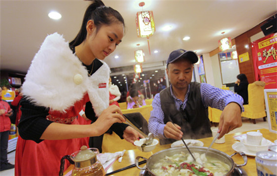 A waitress serves fish at a restaurant in Suzhou, Jiangsu province. (Photo provided to China Daily)