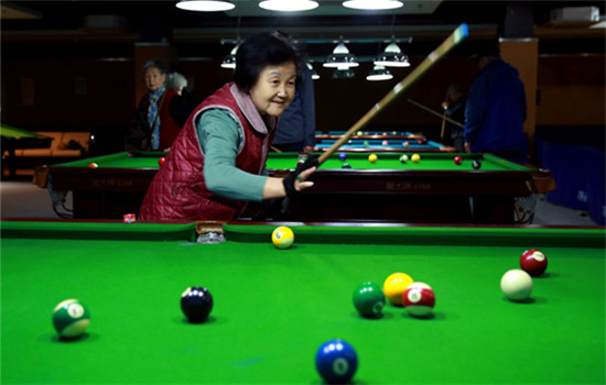 Fan Xiaomei, 70, a retired official of the Ministry of Education, plays pool at the Yanda Golden Age Health Nursing Center in Yanjiao, Hebei province, which is just outside Beijing. (ZOU HONG/CHINA DAILY)