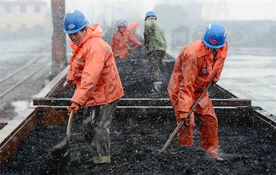 Workers load coal at a railway station in Jiujiang, Jiangxi province. (Photo/China Daily)