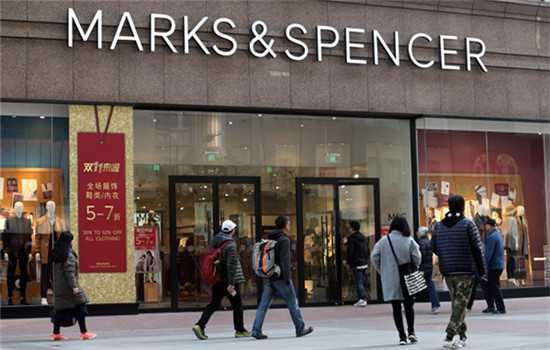 Pedestrians walk past a store of Marks & Spencer in Beijing, Nov 10, 2016. (WANG ZHUANGFEI / CHINA DAILY)