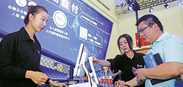 Visitors try to pay for goods using facial recognition software during an online safety promotion week in Wuhan, Hubei province, in September. Payment apps are transforming China's retail sector and have raised people's awareness on cyber safety. (Photo/China Daily)