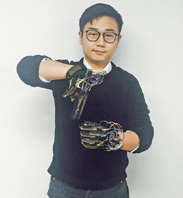 An employee from Yingmi Technology demonstrates a pair of magic gloves that can help translate for those with hearing and speech impairments. (Photo provided to China Daily)