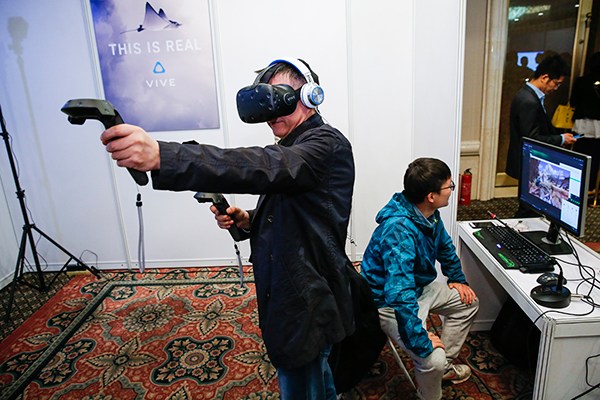 A visitor tests HTC's VR facilities at a 5G technology and test seminar held in Beijing in April. (Photo/Xinhua)