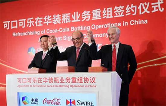 Muhtar Kent(center), chairman and CEO of The Coca-Cola Co, signs the refranchising agreement with Zhao Shuanglian, chairman of COFCO Corp, and John Slosar, chairman of Swire Pacific Ltd on Saturday.(Photo/chinadaily.com.cn)