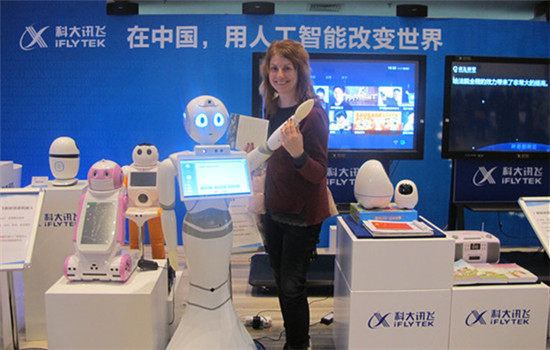 A Bulgarian expert poses for a photo with artificial intelligent robots produced by iFLYTEK Co Ltd, a Hefei-based smart voice enterprise, on Nov 17, 2016. (Photo by Wang Mengzhen/chinadaily.com.cn