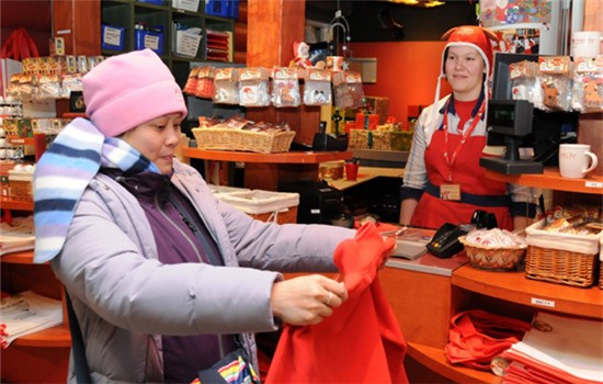A Chinese visitor buys Santa Claus gifts in Rovaniemi, Finland. Baidu Map is expanding into Nordic countries to help Chinese travelers. (ZHAO CHANGCHUN / XINHUA)